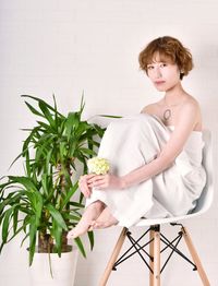 Portrait of young woman sitting on chair