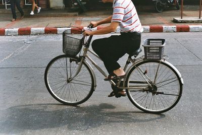 Side view of man riding bicycle on street