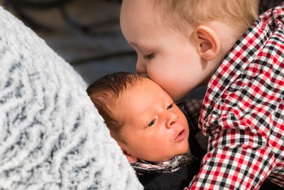 Close-up of sibling kissing newborn brother