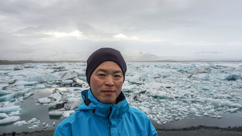 Portrait of man standing by frozen lake