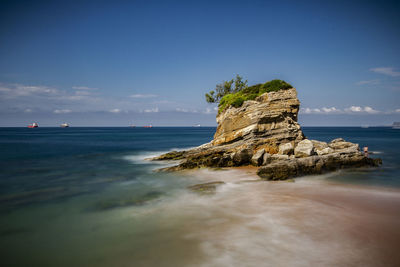 Scenic view of rocks on beach against sky