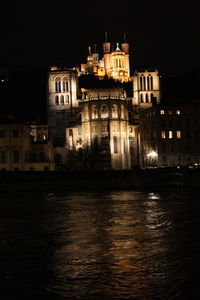 Illuminated city against sky at night