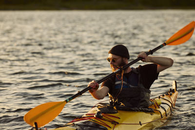 Man kayaking on sunny autumn day