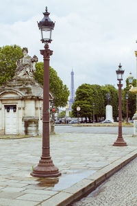 Statue in city against cloudy sky