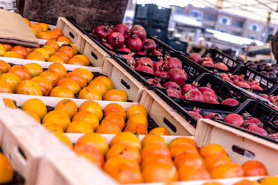 High angle view of persimmons and pomegranates for sale at market stall