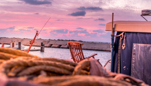 Fishing boat on sea against sky during sunset