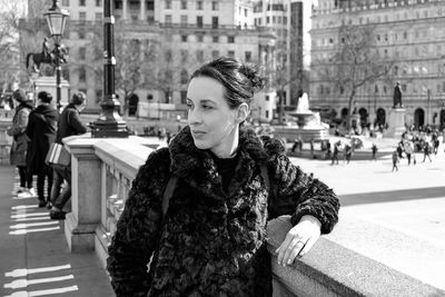 Woman wearing warm clothing while standing in city