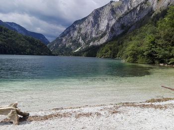 Scenic view of lake by mountains against sky