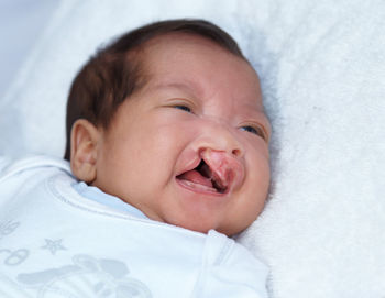 Close-up of cute baby boy sleeping on bed