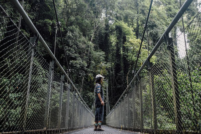 Rear view of woman walking on footbridge