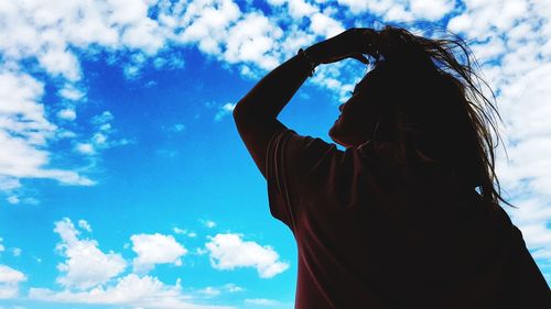 Low angle view of woman against blue sky