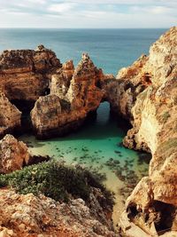 Scenic view of rocks on beach against sky