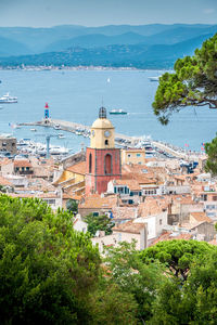 High angle view of townscape by sea against sky