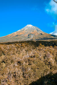 Low angle view of mountain against blue sky
