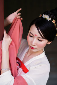 Portrait of a beautiful young woman holding red flower