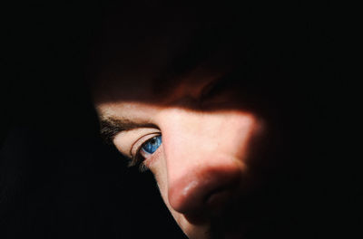 Close-up portrait of man against black background