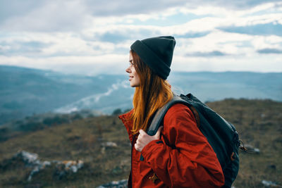 Young woman looking away while standing on mountain