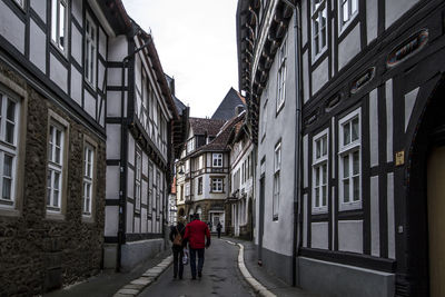 Rear view of man walking in front of building