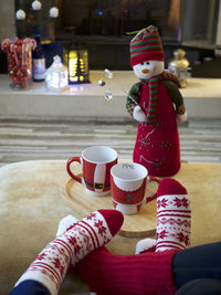 Cozy home, hot chocolate by the fire, fluffy red socks, snuggly feet together