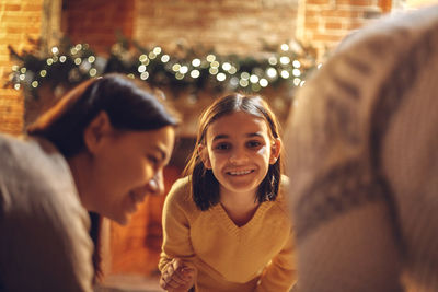 Portrait of smiling friends sitting at home