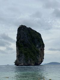 Rock formation in sea against sky