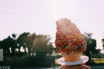 Close-up of ice cream cone against sky