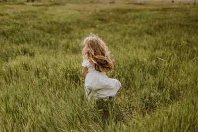 Rear view of woman sitting on field