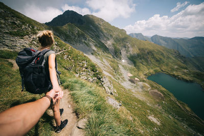 Cropped hand holding woman on mountain