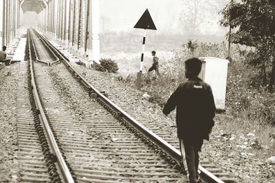 Rear view of man on railroad track