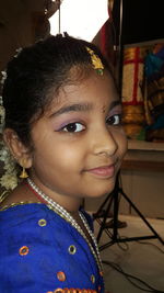 Close-up portrait of smiling girl looking away at home