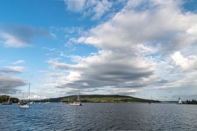 Sailboats in sea against sky