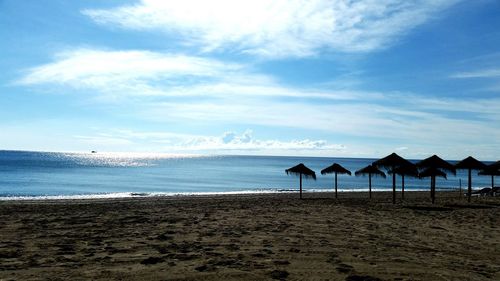 Scenic view of beach against cloudy sky