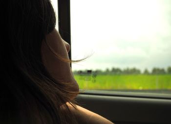 Thoughtful woman looking through window while traveling in car