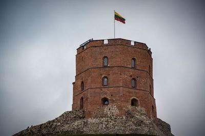 Low angle view of flag on old castle against sky