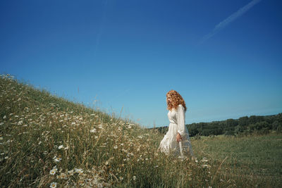 Woman standing on field against clear sky