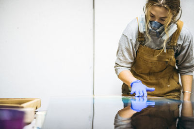 Female resin artist using hands to perfect artwork