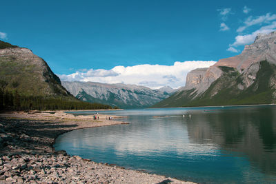 Scenic view of lake and mountains against blue sky