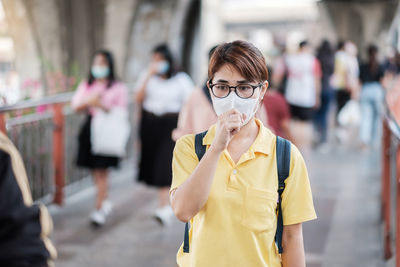 Woman coughing while wearing pollution mask