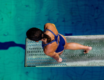 High angle view of swimmer walking on diving platform over swimming pool