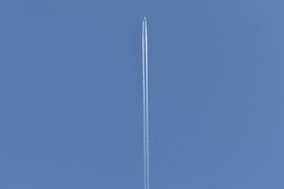 Low angle view of vapor trail against blue sky
