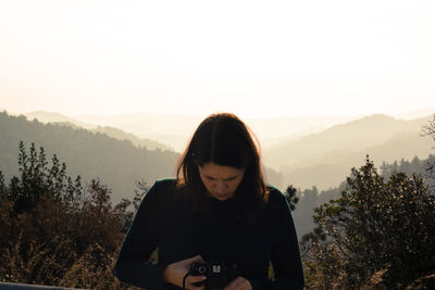 Young woman looking at camera while standing outdoors