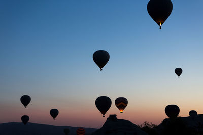 Low angle view of hot air balloons against sky during sunset