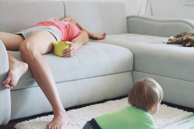 Rear view of woman sitting on sofa at home