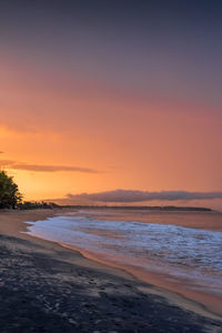 People walking on the beach. beautiful sunset over the sea, orange sky. arugam bay, ceylon