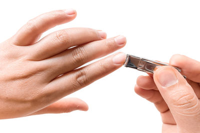 Close-up of hand holding hands over white background