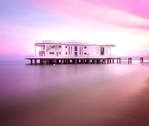 Building by sea against sky during sunset