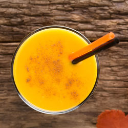 High angle view of yellow drink on table