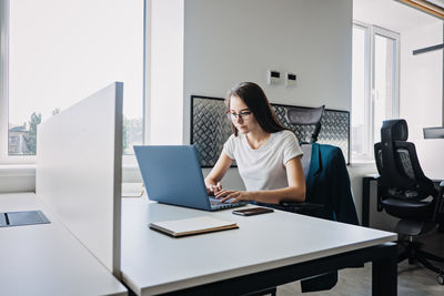 Young female programmer web developer working on computer software in modern office. web designer