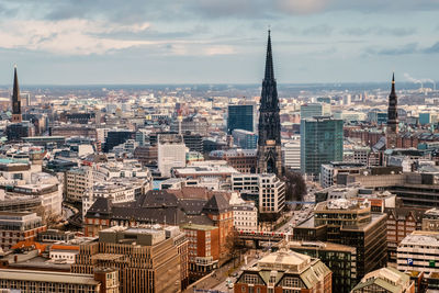 View of cityscape against cloudy sky