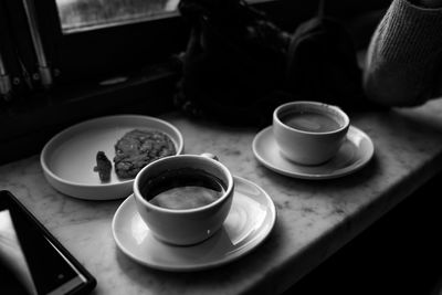 High angle view of coffee and cups on table